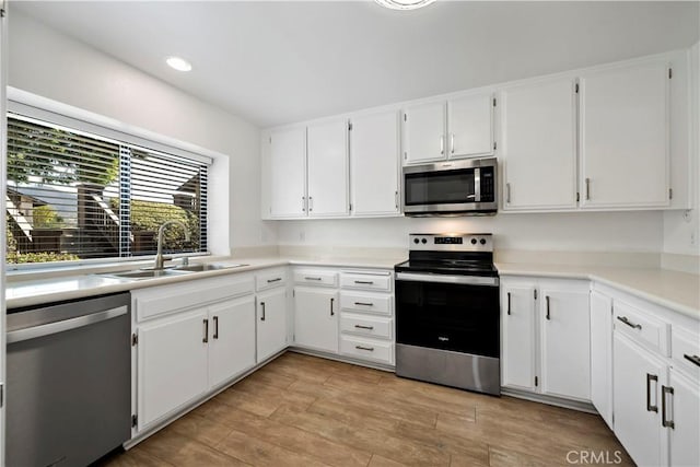 kitchen featuring sink, white cabinets, and appliances with stainless steel finishes