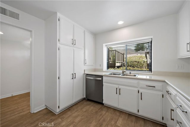 kitchen with white cabinets, dishwasher, light hardwood / wood-style floors, and sink