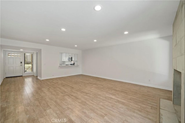 unfurnished living room featuring a fireplace and light wood-type flooring