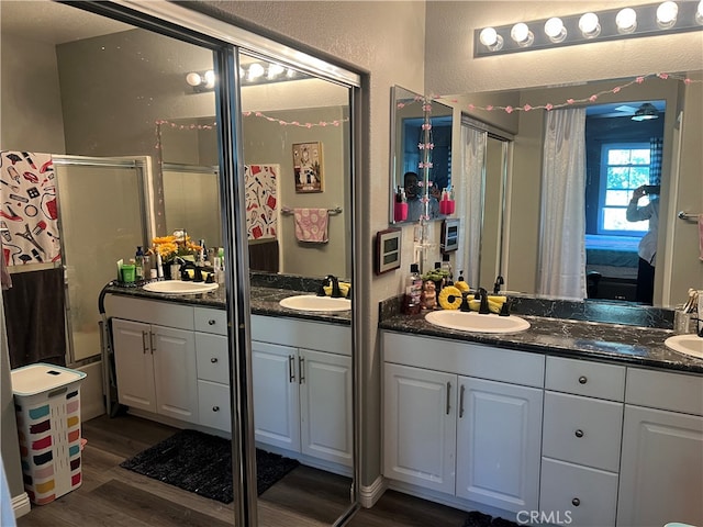 bathroom with wood-type flooring, vanity, and walk in shower