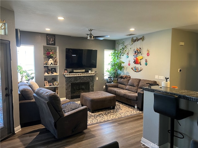 living room with ceiling fan, dark hardwood / wood-style floors, and a fireplace