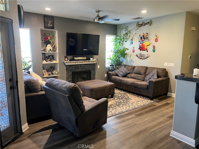 living room featuring wood-type flooring, ceiling fan, and a wealth of natural light