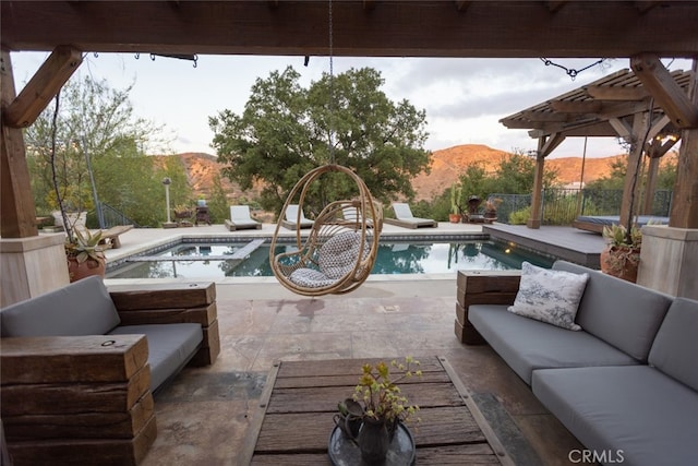 view of patio / terrace with a swimming pool with hot tub, an outdoor hangout area, and a mountain view