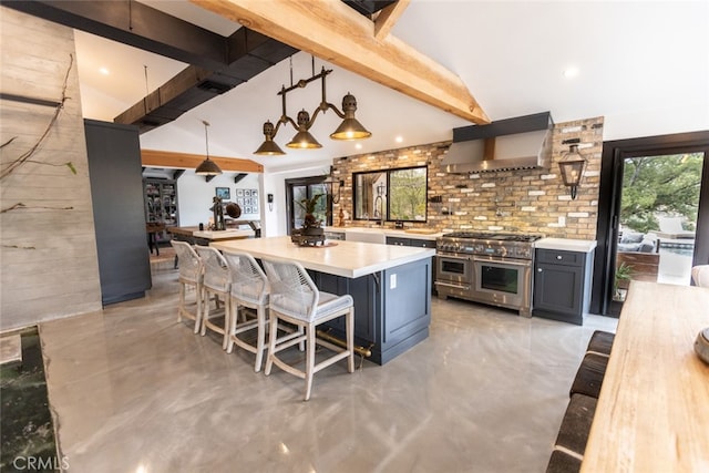 kitchen featuring a kitchen breakfast bar, exhaust hood, hanging light fixtures, range with two ovens, and tasteful backsplash