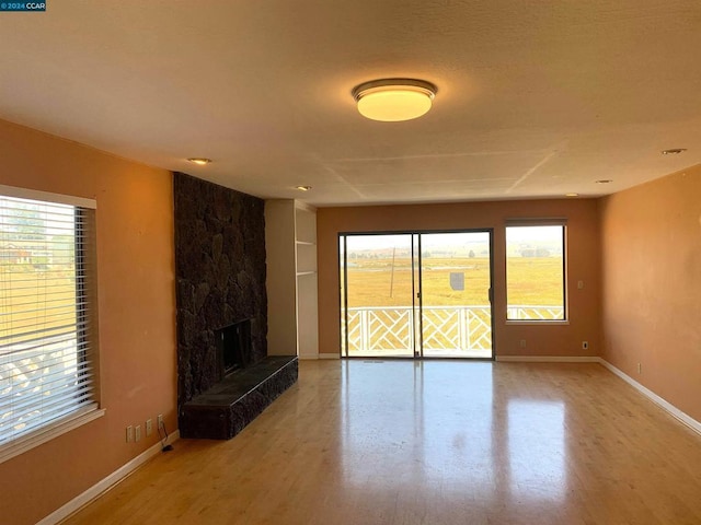 unfurnished living room featuring a fireplace and hardwood / wood-style floors