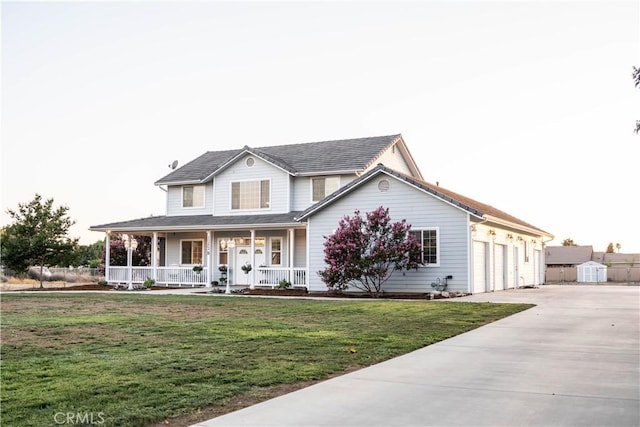 view of front facade with a garage, a front lawn, a storage unit, and a porch