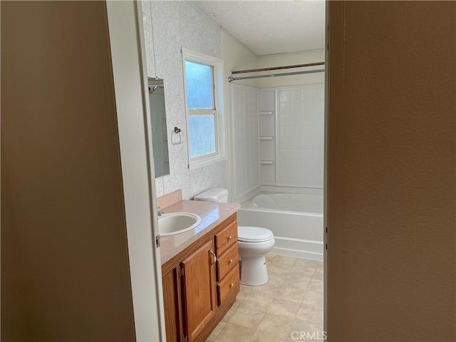 full bathroom with vanity, toilet,  shower combination, and a textured ceiling