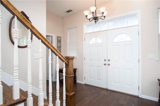 entryway with dark hardwood / wood-style floors and a chandelier