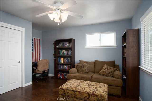 living room with ceiling fan and dark hardwood / wood-style flooring