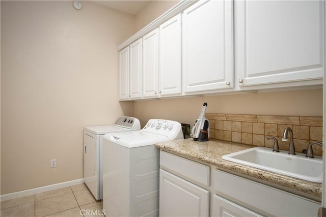 laundry room with light tile patterned flooring, cabinets, sink, and washing machine and dryer