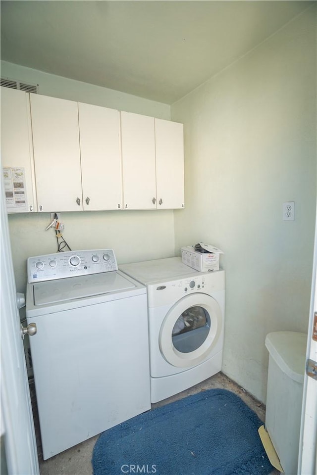 washroom with cabinets and washing machine and clothes dryer