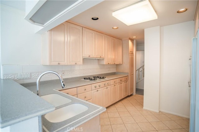 kitchen featuring white gas cooktop, sink, backsplash, and light tile patterned floors