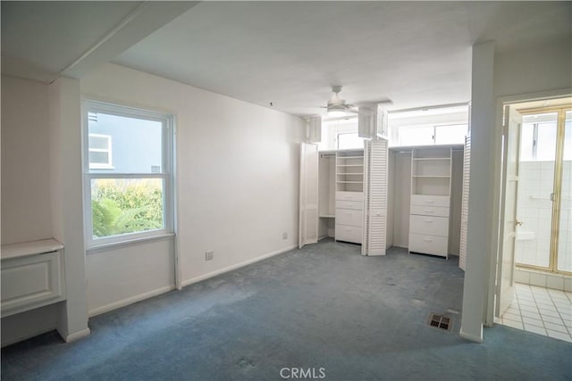 unfurnished bedroom with ensuite bathroom, a closet, carpet, and ceiling fan