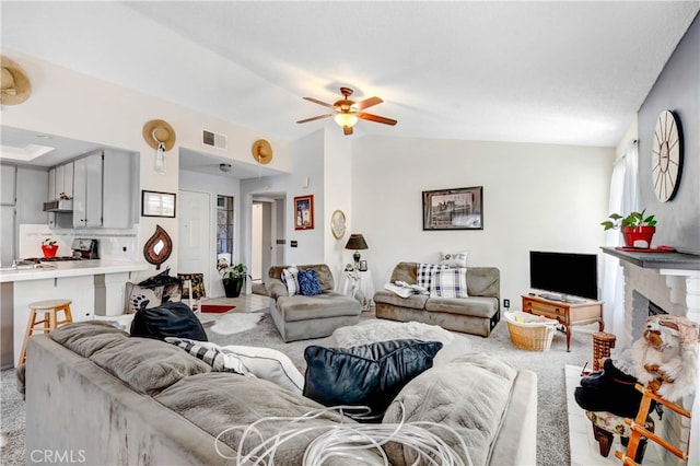 carpeted living room featuring vaulted ceiling and ceiling fan