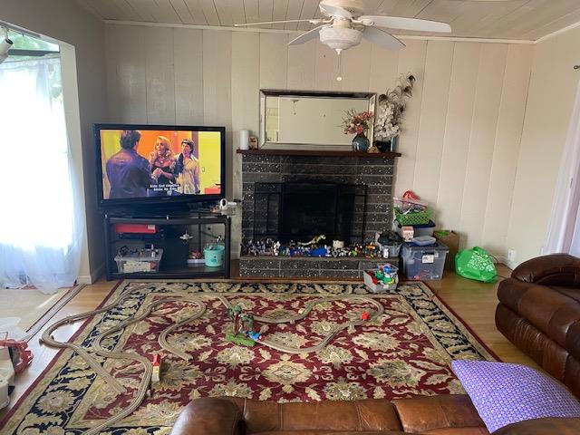 living room with hardwood / wood-style flooring, plenty of natural light, and wooden walls