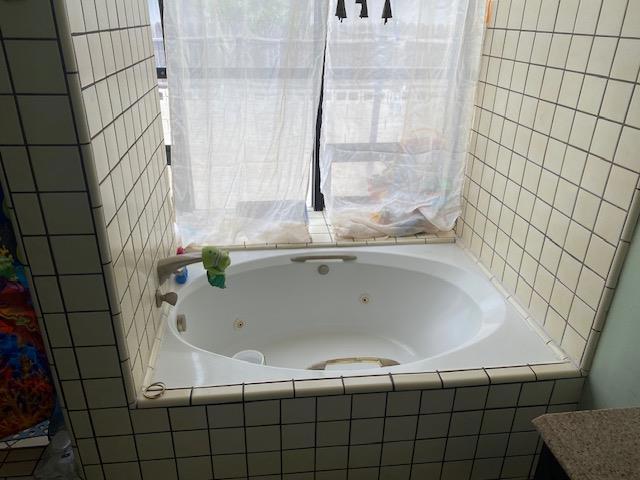 bathroom featuring a relaxing tiled tub