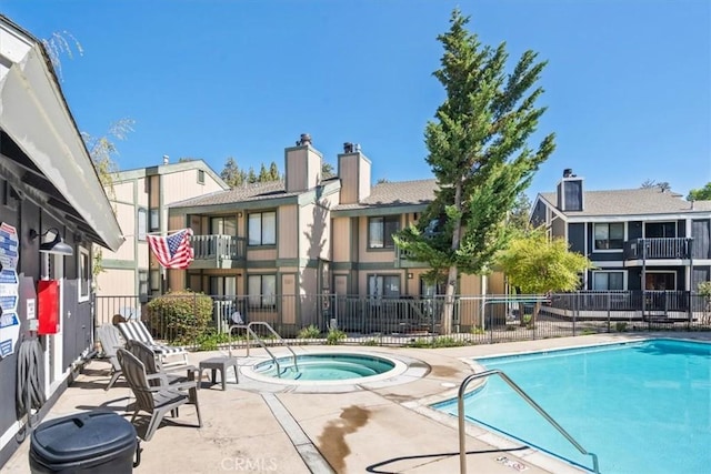 view of swimming pool featuring a community hot tub and a patio