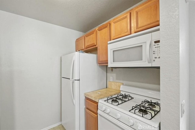 kitchen featuring white appliances and a textured ceiling