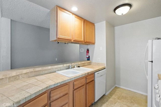 kitchen featuring sink, tile countertops, a textured ceiling, and white appliances