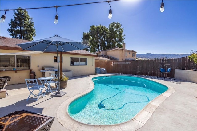 view of pool with a fenced in pool, a patio area, a mountain view, and a fenced backyard