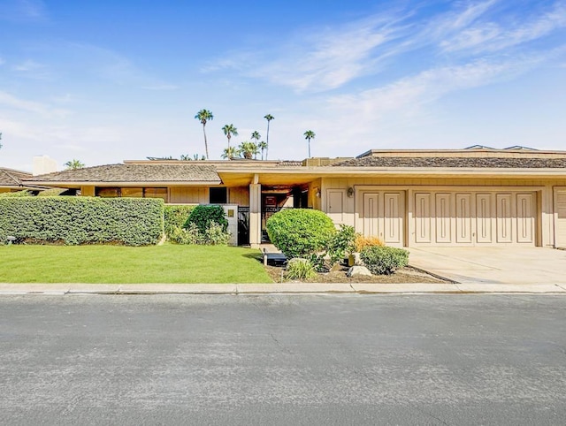 single story home featuring a front yard and a garage