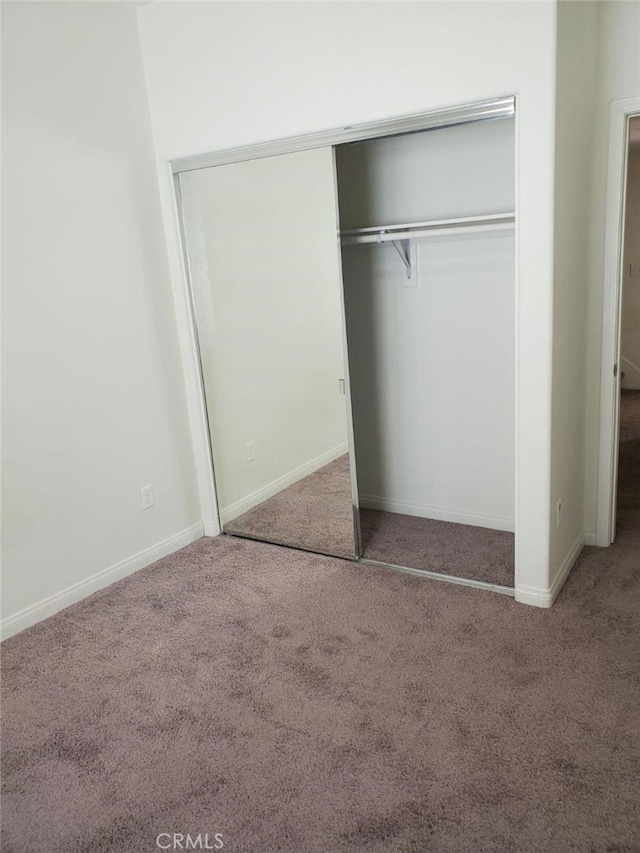 unfurnished bedroom with carpet floors and a closet