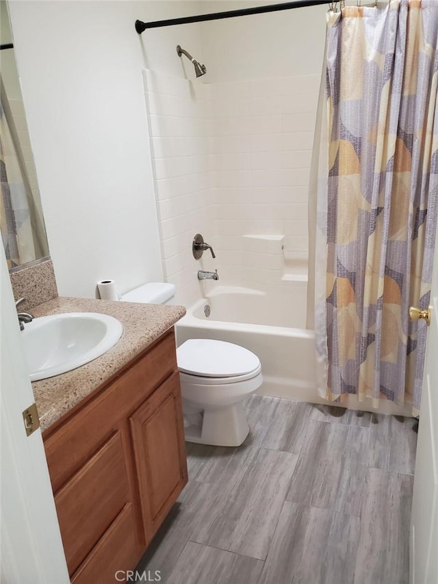 full bathroom with wood-type flooring, vanity, toilet, and shower / bath combo with shower curtain