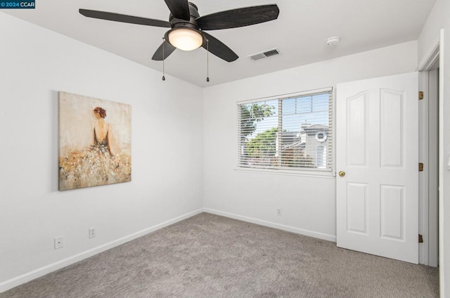 carpeted empty room featuring ceiling fan