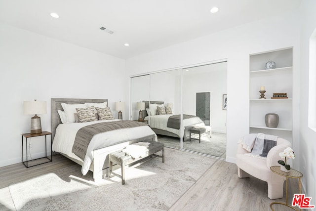 bedroom with a closet and light hardwood / wood-style floors