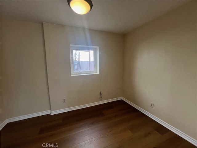 spare room with dark wood-type flooring