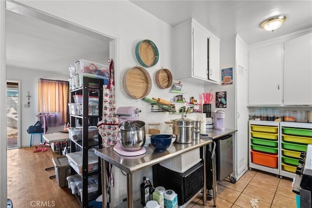 kitchen featuring light wood-type flooring, white cabinetry, and stainless steel dishwasher