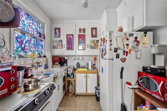 kitchen featuring white cabinets, white refrigerator, and light parquet floors