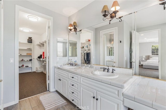 bathroom featuring wood-type flooring, vanity, and a notable chandelier