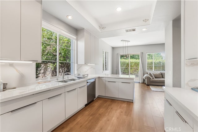 kitchen with white cabinets, plenty of natural light, light hardwood / wood-style floors, and kitchen peninsula