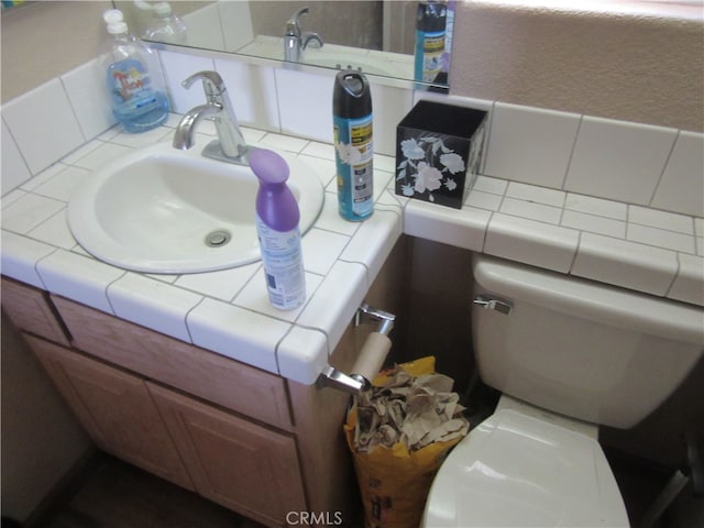 bathroom featuring tasteful backsplash, vanity, and toilet