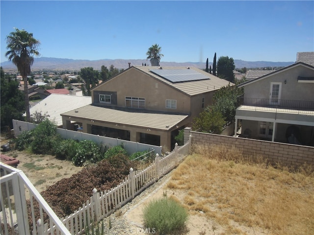 back of house featuring a mountain view and a balcony