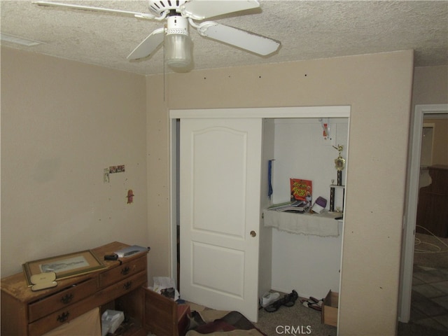 bedroom with a textured ceiling, ceiling fan, and a closet