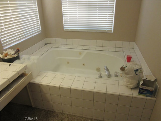 bathroom featuring tiled tub and plenty of natural light