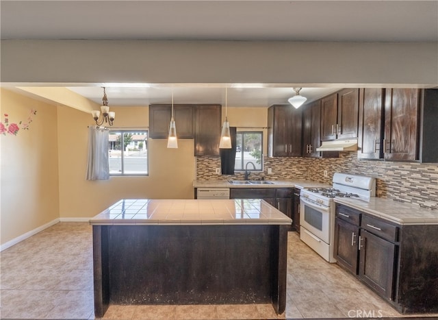 kitchen featuring a kitchen island, backsplash, sink, decorative light fixtures, and white appliances