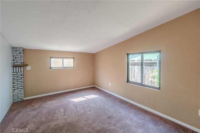 carpeted spare room with lofted ceiling