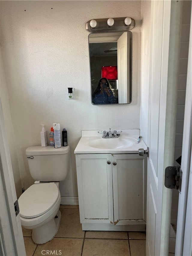 bathroom featuring toilet, tile patterned floors, and vanity