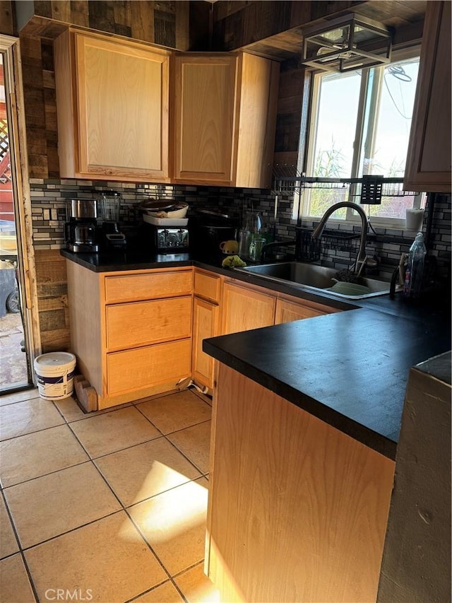 kitchen featuring decorative backsplash, sink, and light tile patterned flooring