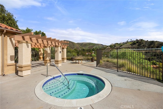 view of pool featuring a hot tub, a mountain view, a pergola, and a patio area