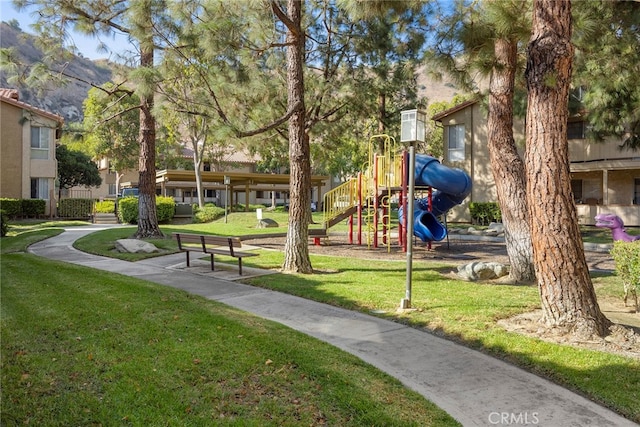 view of home's community with a lawn and a playground