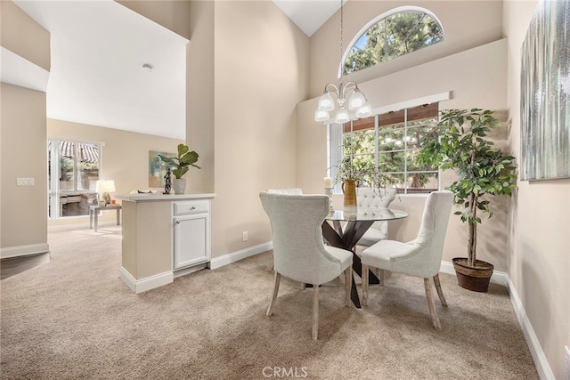 dining space featuring high vaulted ceiling, carpet, and an inviting chandelier