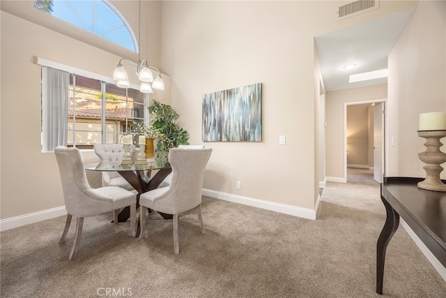 dining space featuring carpet floors and a chandelier