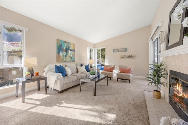 carpeted living room with vaulted ceiling and a fireplace