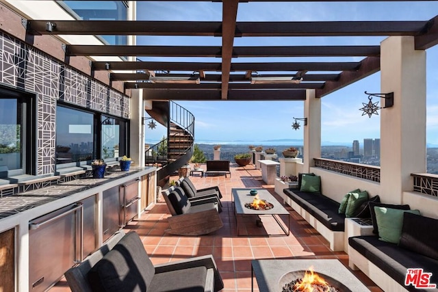 view of patio with a pergola, an outdoor living space with a fire pit, and exterior kitchen