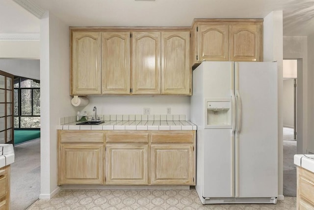 kitchen featuring sink, white fridge with ice dispenser, and light brown cabinets