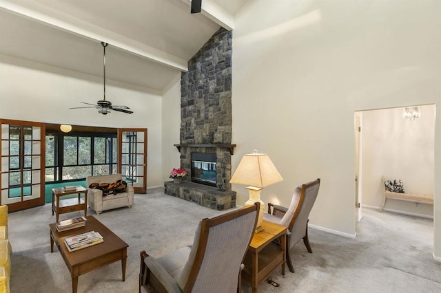 living room featuring beamed ceiling, a stone fireplace, high vaulted ceiling, and french doors